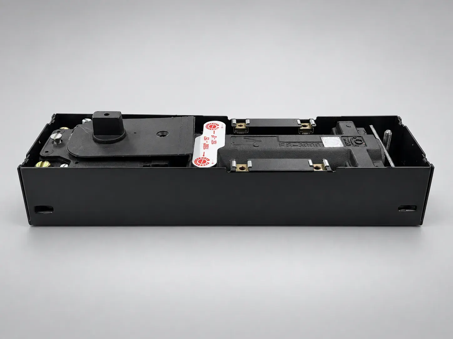 Sterling FS 3000 floor spring inside a black box, cover plate removed, front view from above, studio photograph