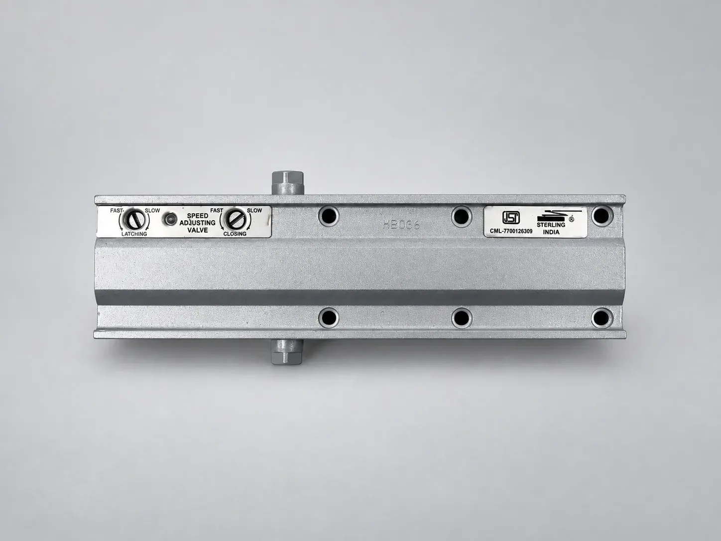 Door closer body with the cover removed, showing the speed adjusting valve plate for latching and closing and the ISI label plate, front view, studio photograph